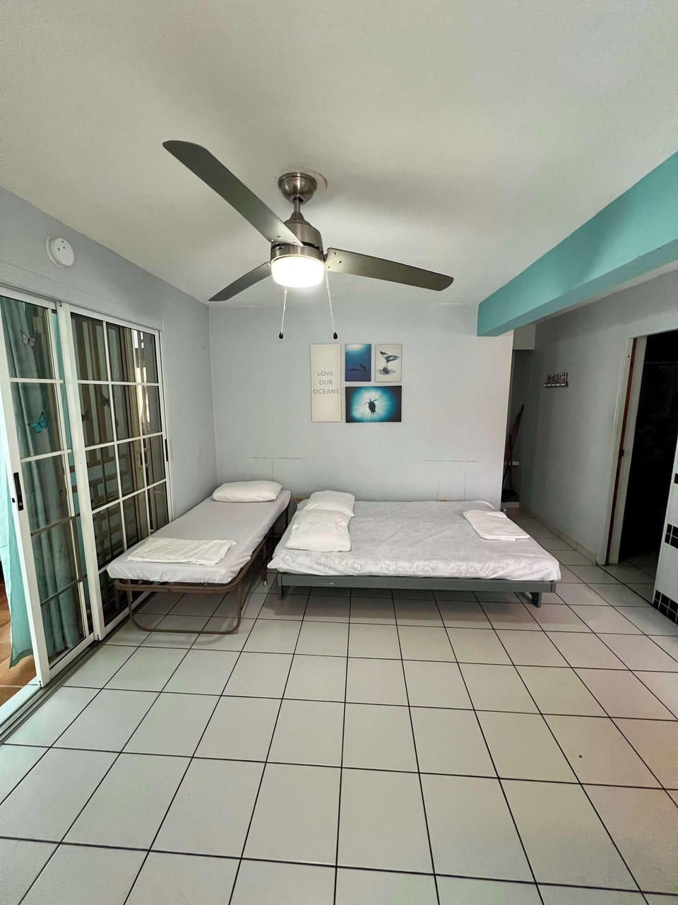 Light-filled room with ceiling fan and direct patio access.