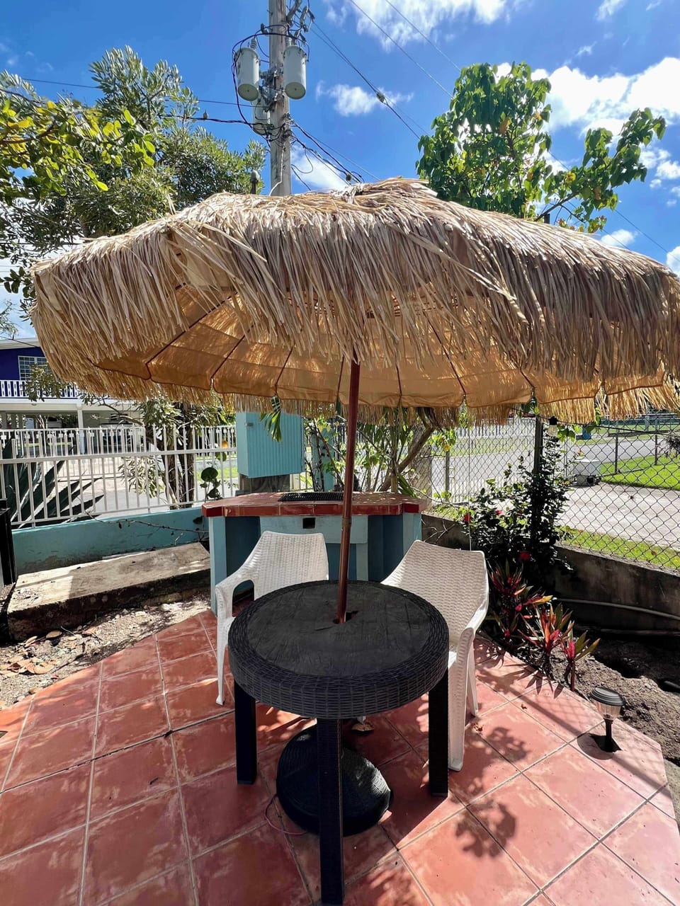 Charming tiki umbrella table on the tiled patio, a fun outdoor spot to relax.