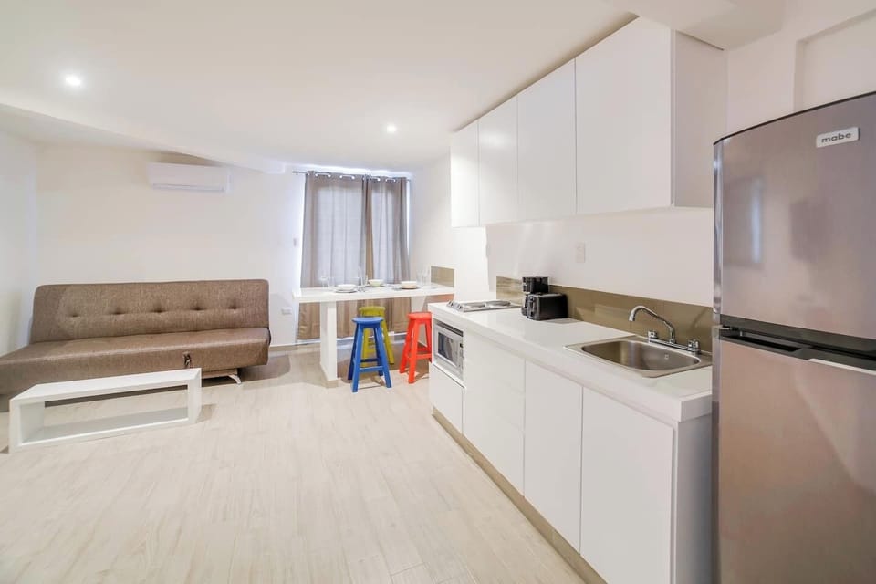 Kitchen with refrigerator, toaster, coffee maker, stovetop and microwave