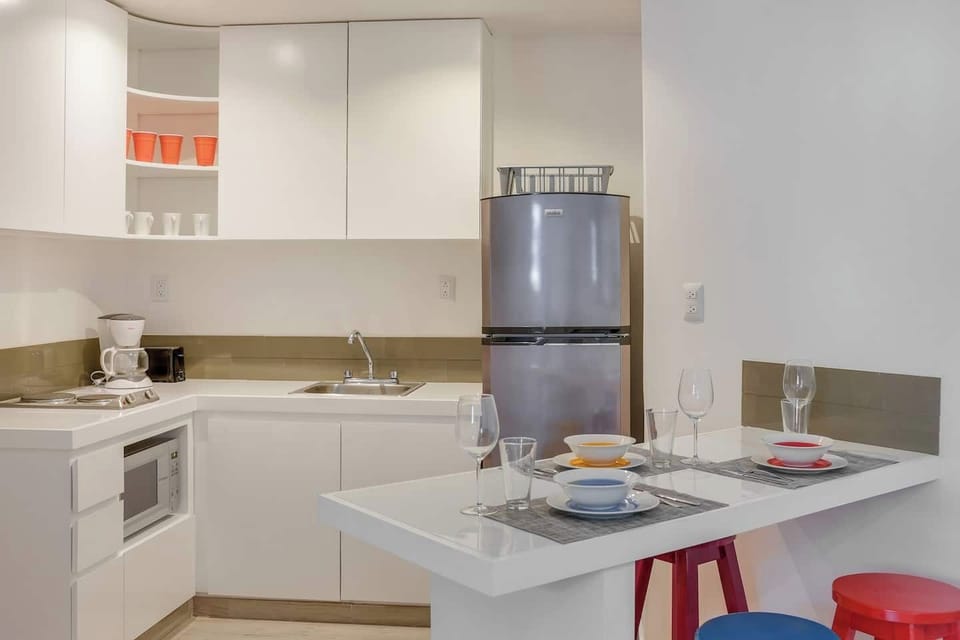Kitchen with full refrigerator, microwave, coffee maker, toaster and dishes
