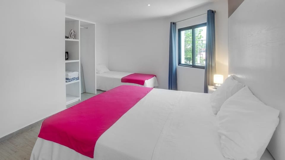 Large room with a king size bed and an individual bed with air conditioning, security box, hair dryer and iron