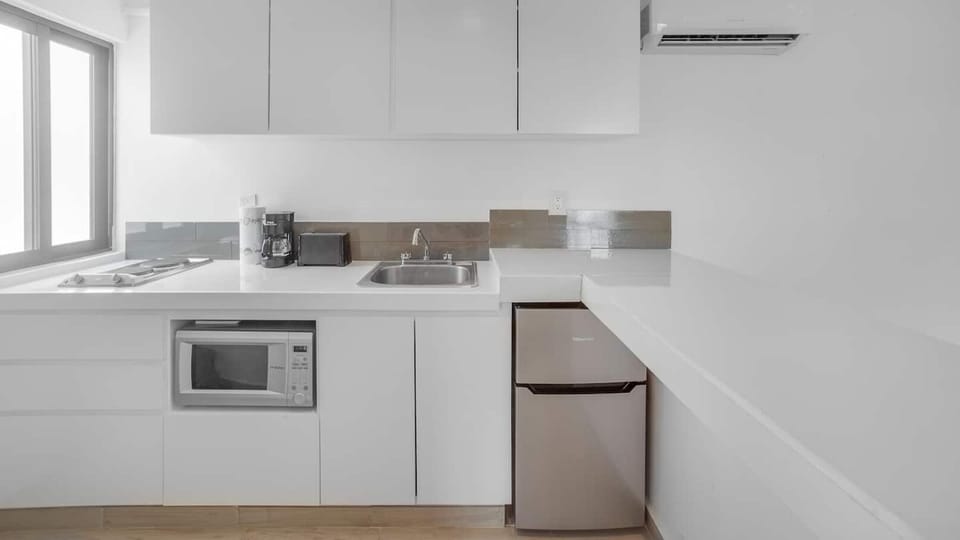 Kitchen with two stovetop burners, coffee maker, microwave and small refrigerator