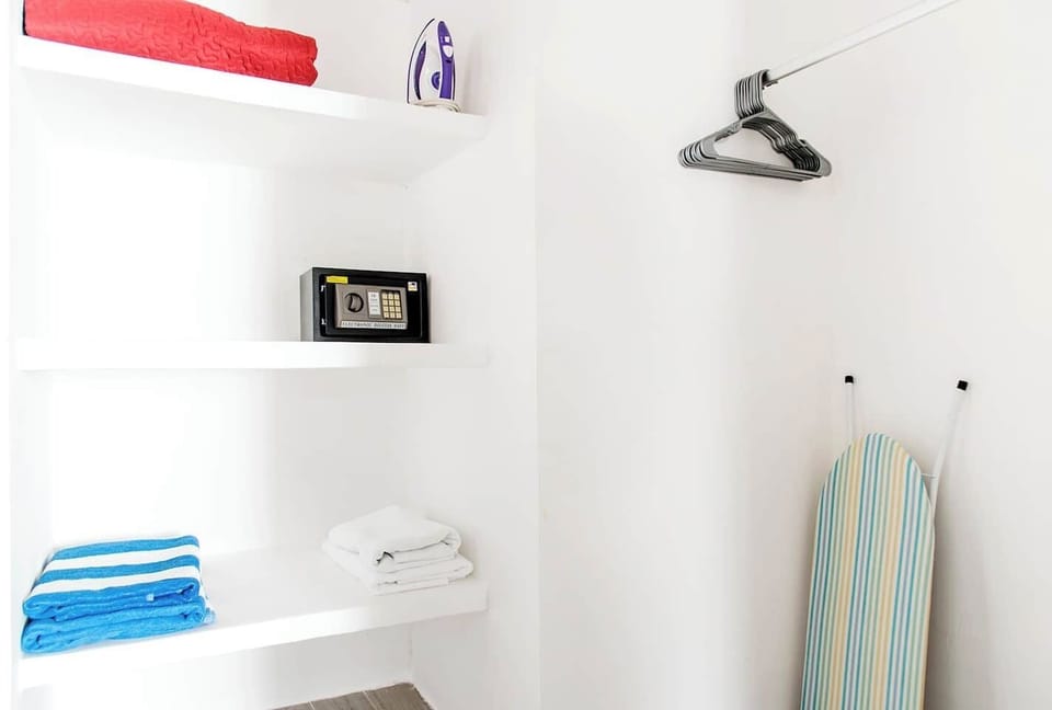 Closet with bath and beach towels, security box, iron and hangers