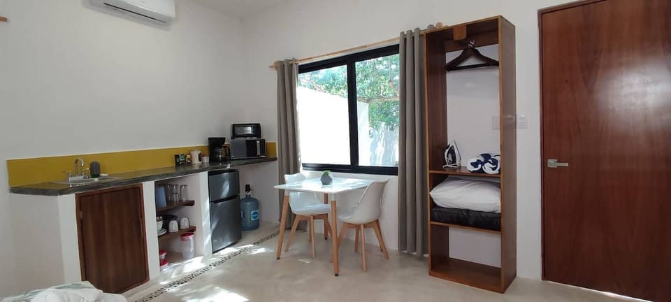 Kitchenette with Microwave, toaster oven, Coffee maker with coffee and sugar, and dining area.
