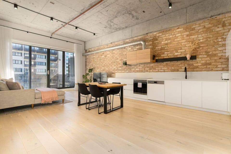 Open and airy living space with high ceilings and a stylish industrial touch, perfect for unwinding or entertaining.