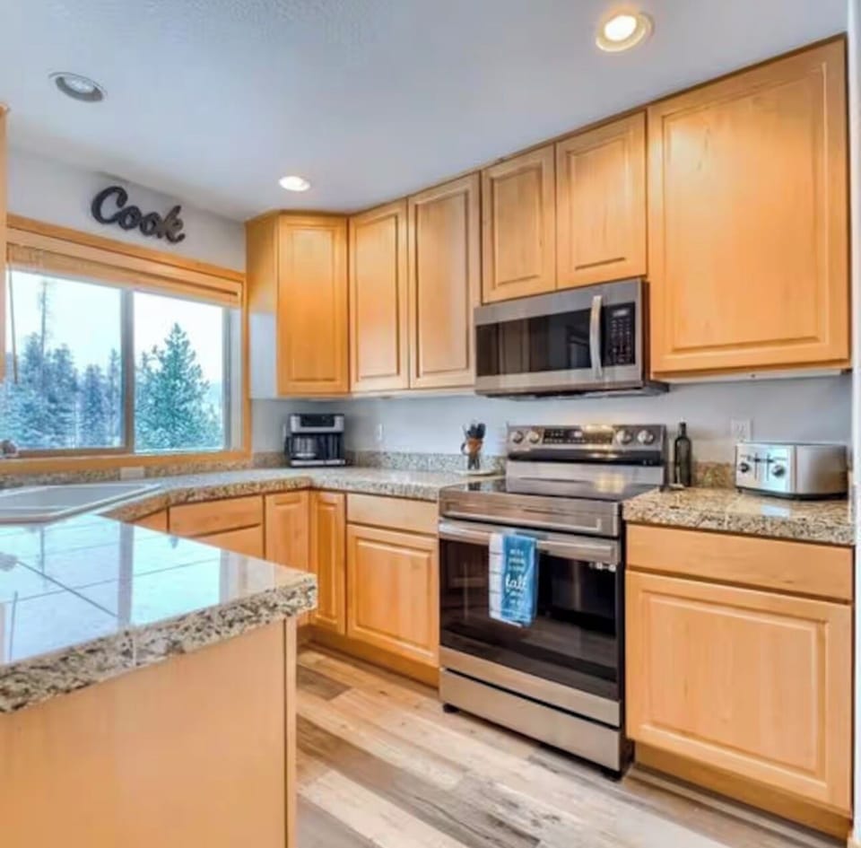 Fully equipped kitchen with a great window view and natural light.
