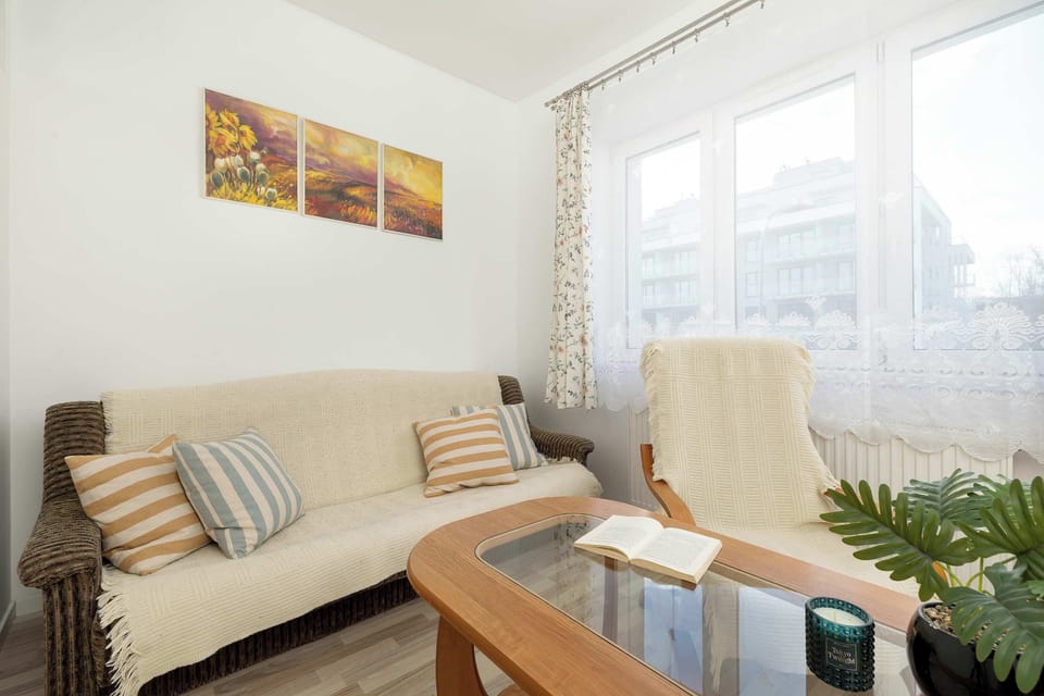 The sleeping area contains a comfortable cream-colored sofa and a classic wooden coffee table. Soft lighting and a warm color palette create a cozy atmosphere for guests.
