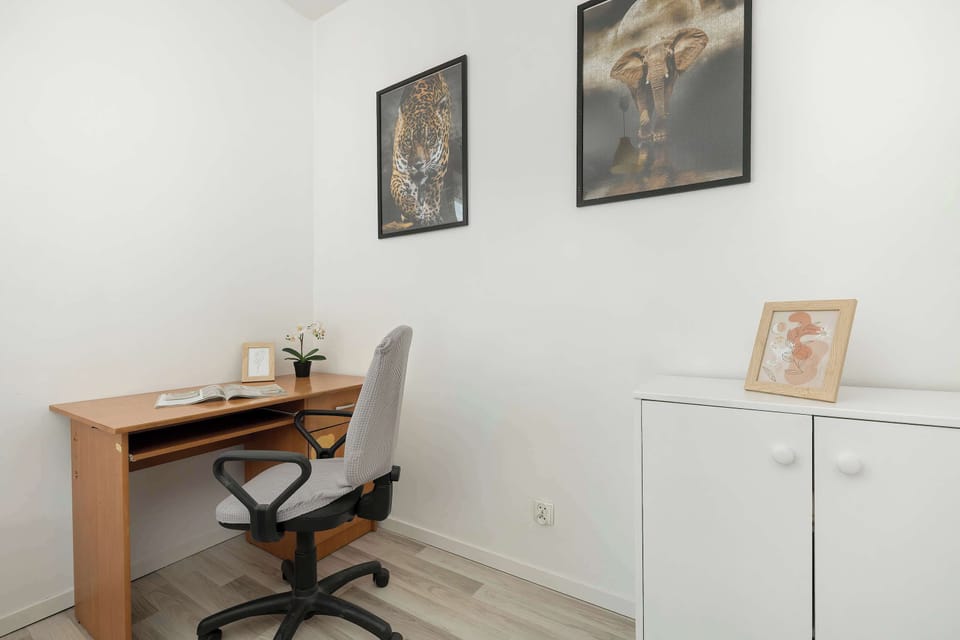 A dedicated workspace features a simple wooden desk, a professional office chair, and minimalist wall decorations. This corner provides a quiet spot for business travelers to handle tasks.