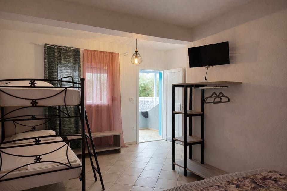 View of the studio showing the bunk bed, TV, and access to the patio, with natural light coming in through the door.