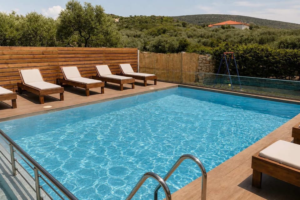 Shared swimming pool with sunbeds arranged around the deck, offering a relaxed setting for swimming, sunbathing, or spending time outside without needing to leave the property.