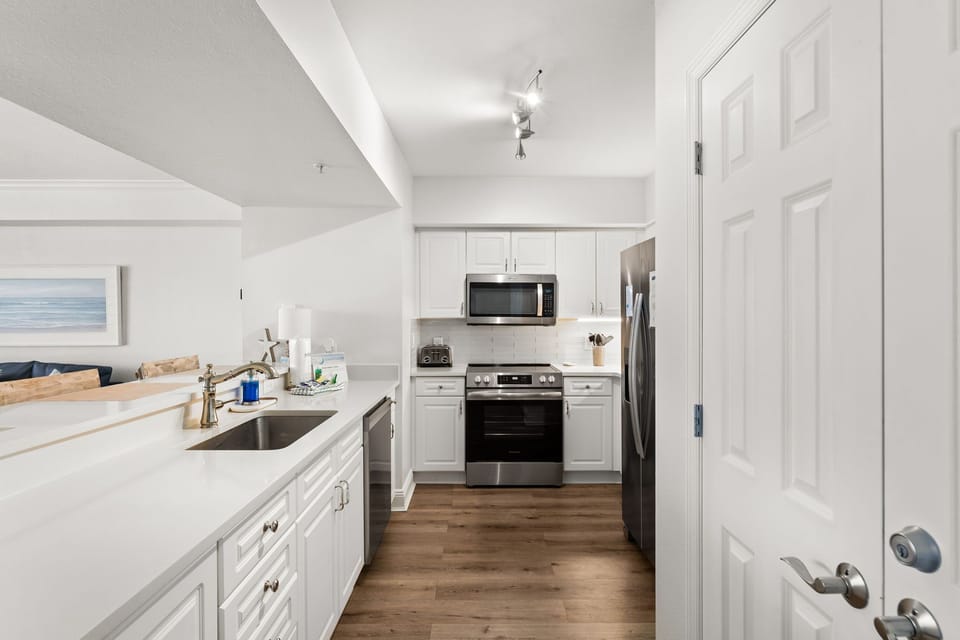 The fully equipped kitchen features quartz countertops, stainless-steel appliances, and has everything you need to prepare meals for family & friends.