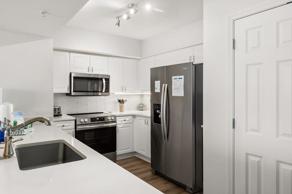 The fully equipped kitchen features quartz countertops, stainless-steel appliances, and has everything you need to prepare meals for family & friends.