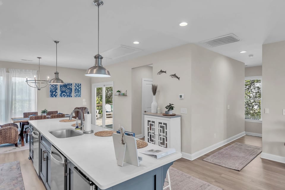 Your open-concept kitchen flows seamlessly into the dining area, where pendant lights illuminate the spacious island perfect for morning coffee or evening conversations.