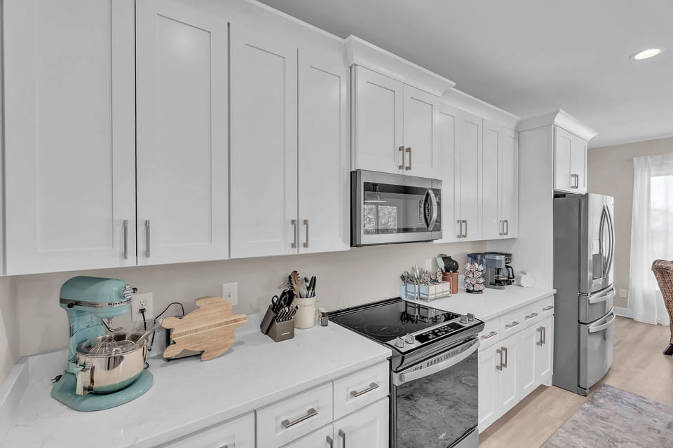Step into your fully equipped kitchen where culinary dreams come alive with pristine white cabinets, stainless steel appliances, and everything you need to create memorable meals.