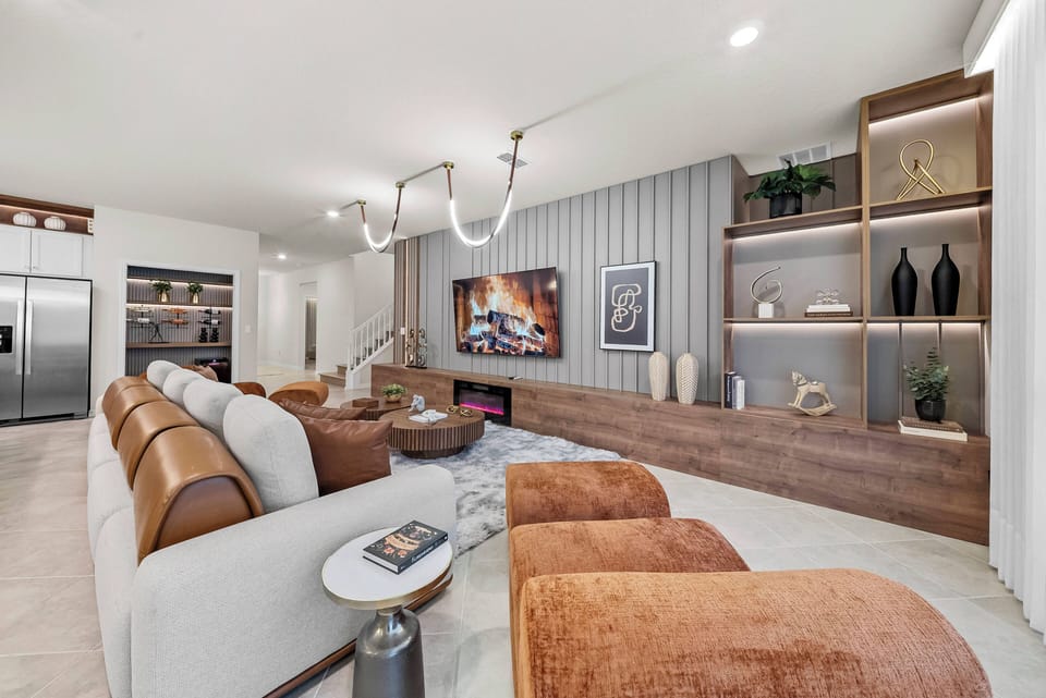 Relax in the spacious living area, where a soft gray sectional and warm leather chairs invite you to unwind. Natural light enhances the stylish wood accents and modern decor, making it the perfect retreat after a day of adventure.