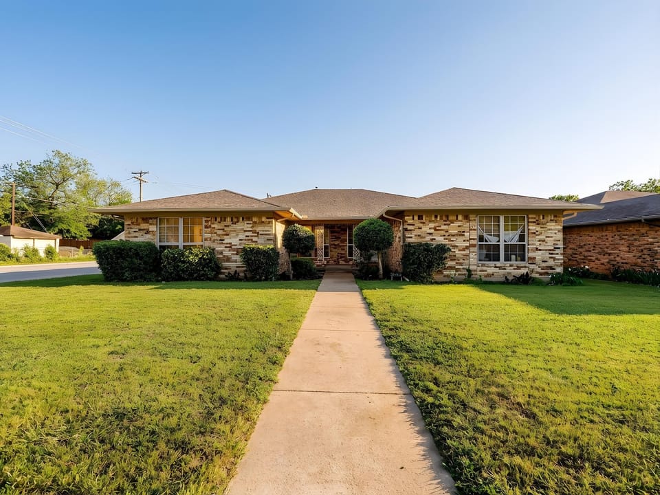 Charming brick ranch home with well-maintained lawn and landscaping in a quiet residential neighborhood.
