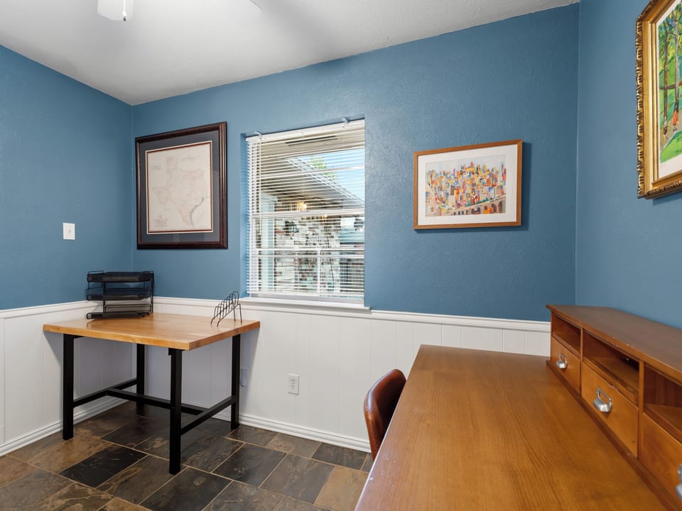 Your dedicated workspace features warm wood furnishings and inspiring artwork, creating the perfect environment for productive work sessions.