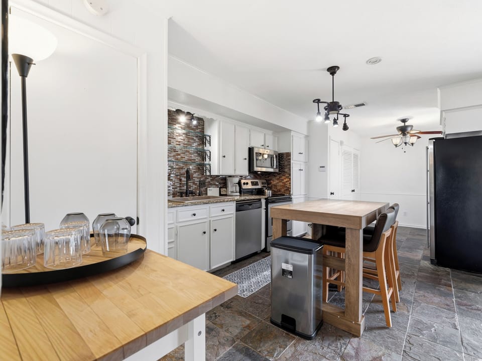 Your spacious, fully-equipped kitchen invites you to whip up meals with modern appliances, charming stone accents, and a breakfast island perfect for morning coffee or casual dining.