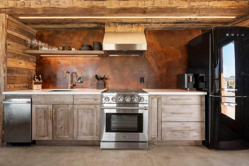Retro Smeg fridge, 5-burner Thor range, Bosch dishwasher — culinary suite, not camp kitchen