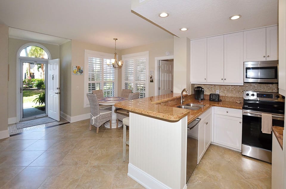 Your bright kitchen flows into a cozy dining nook, perfect for morning coffee or preparing meals while enjoying garden views.