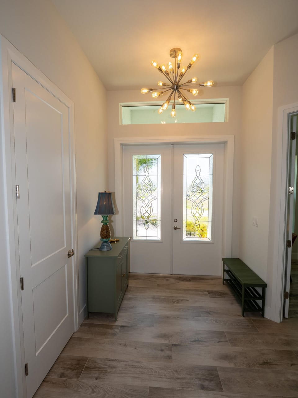 Bright and airy entryway with elegant chandelier lighting