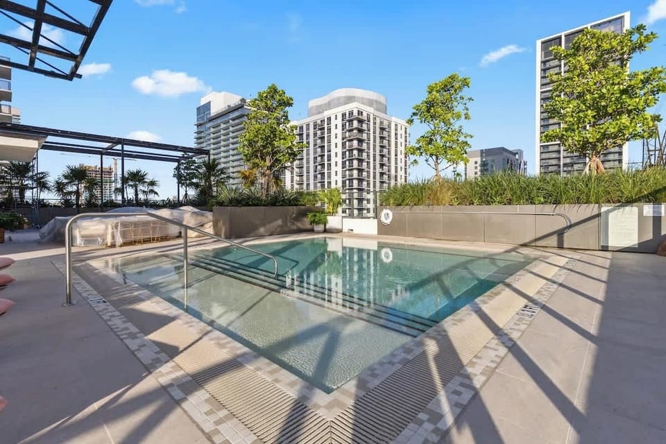 Resort-style amenities including rooftop pool & jacuzzi, cabanas, BBQ area, gym, sauna, coworking spaces, theater, gaming lounge, café, and 24/7 security