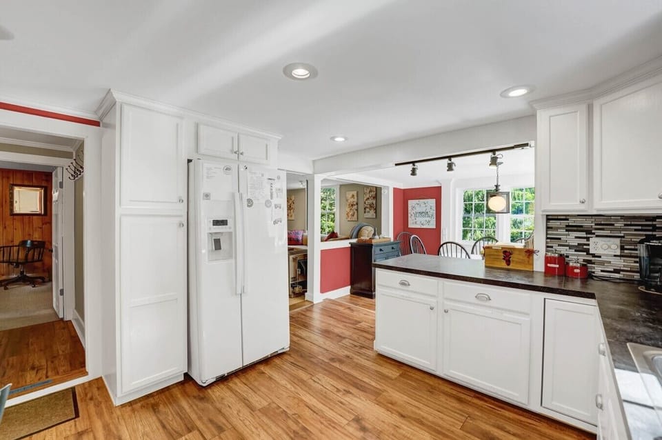Kitchen | White Side-by-Side Refrigerator | Dark Countertops & Hardwood Floors