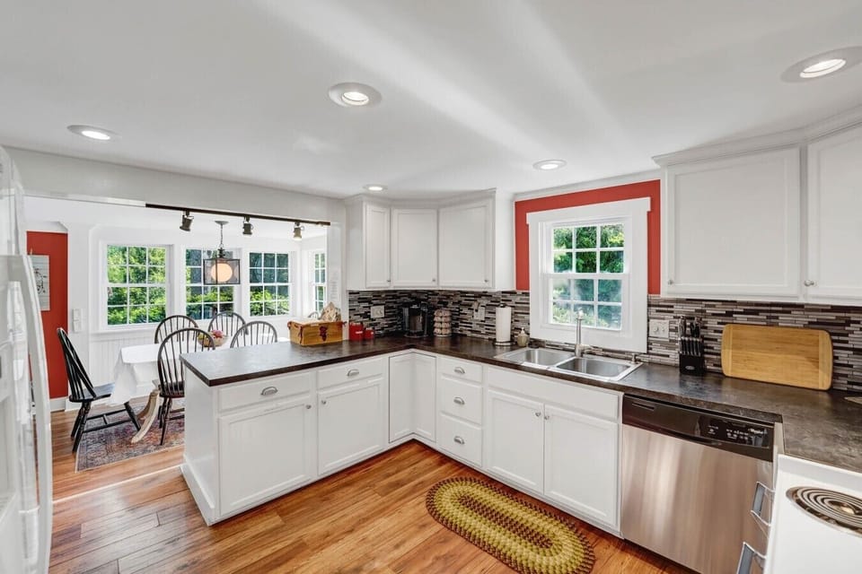 Kitchen | White Cabinetry & Dark Countertops | Stainless Dishwasher & Breakfast Nook Access
