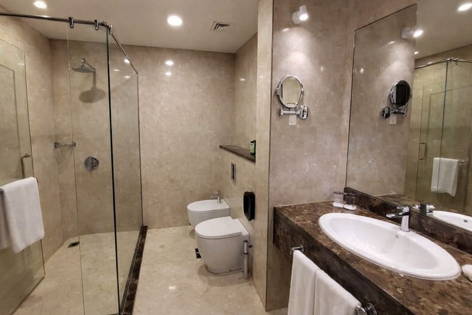 Refresh in a sleek marble bathroom with walk-in shower.