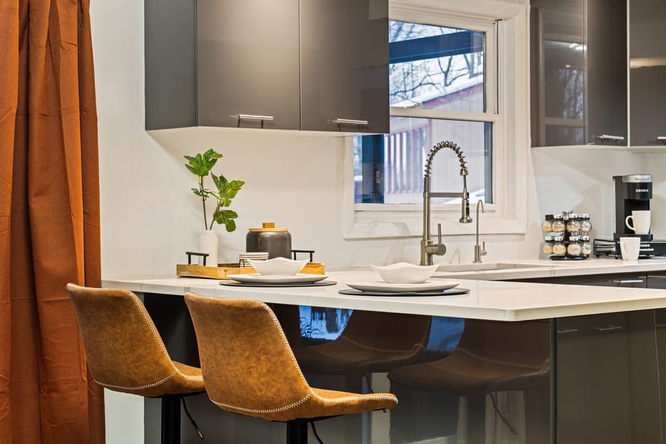Modern kitchen with breakfast bar, coffee station, and seating.