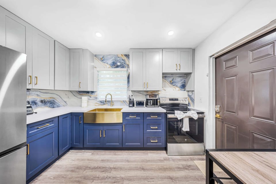 Cook in style during your vacation! This luxury kitchen features gorgeous blue cabinets, high-end gold accents, a massive farmhouse sink, and a coffee station. Perfect for family breakfast before the beach