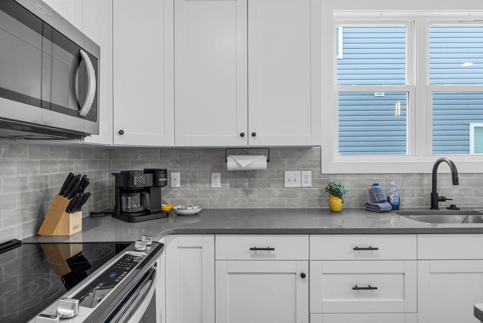 Modern kitchen fully stocked with cookware, coffee essentials, Keurig, and everything needed for cooking meals and entertaining during your stay.