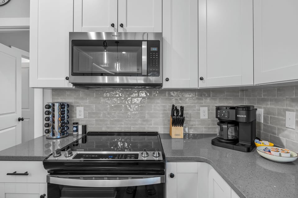 Modern kitchen fully stocked with cookware, coffee essentials, Keurig, and everything needed for cooking meals and entertaining during your stay.