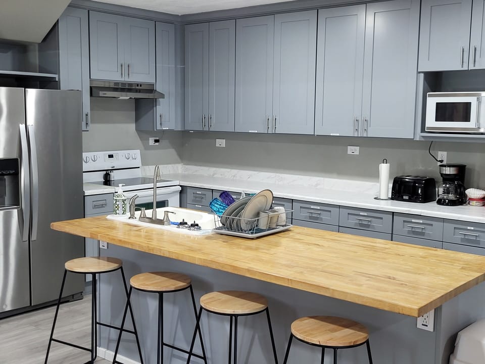 Bar seating at island plus full kitchen with oven, fridge, and microwave