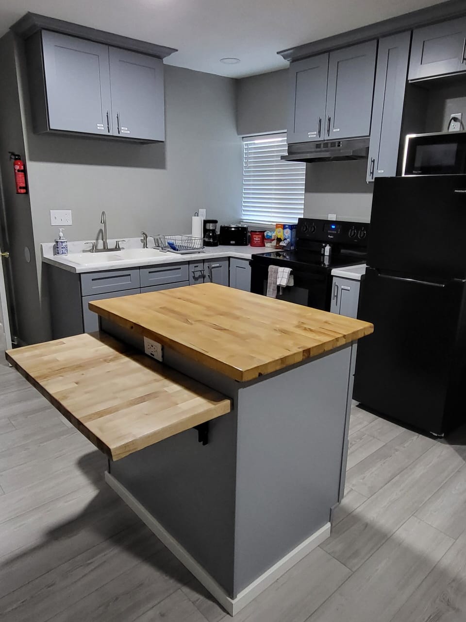 Kitchen with full oven, range, fridge, island, and dining/serving area