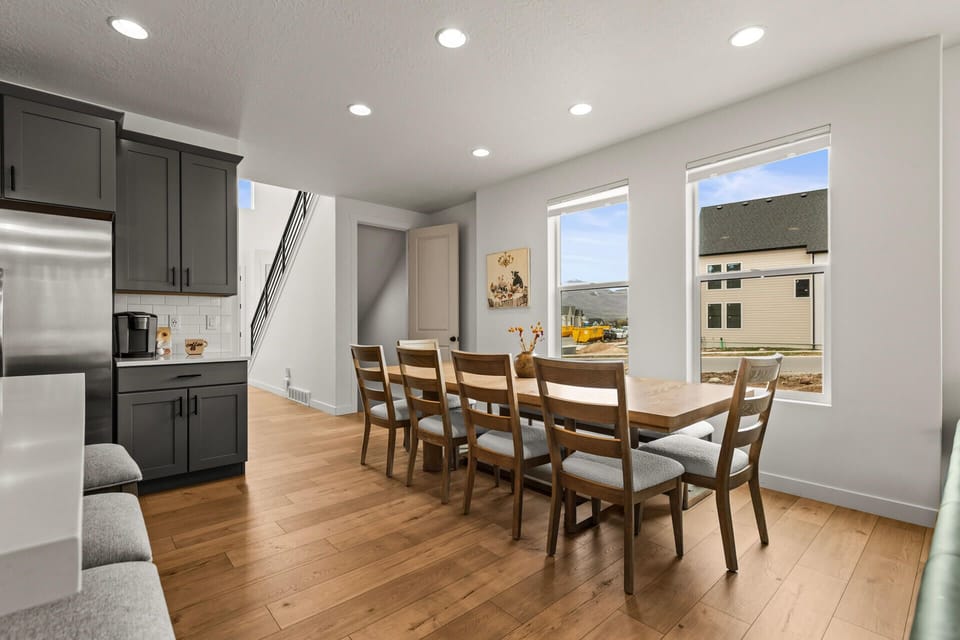Gather around your spacious dining table for memorable meals, with natural light streaming through large windows and modern kitchen close by.