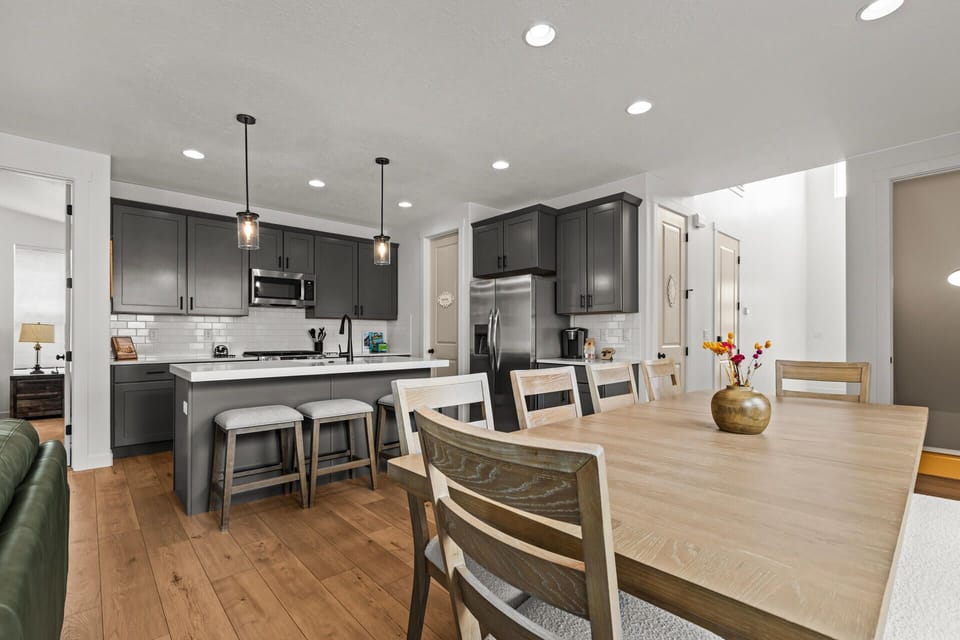 You'll love preparing meals in this modern kitchen with sleek gray cabinets, granite counters, and stainless appliances, then gathering around the spacious dining table.