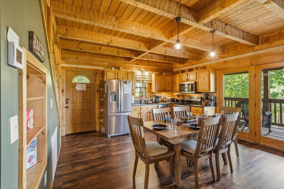 Gather around this beautiful wood dining table where warm cabin vibes meet modern convenience in your fully-equipped kitchen space.