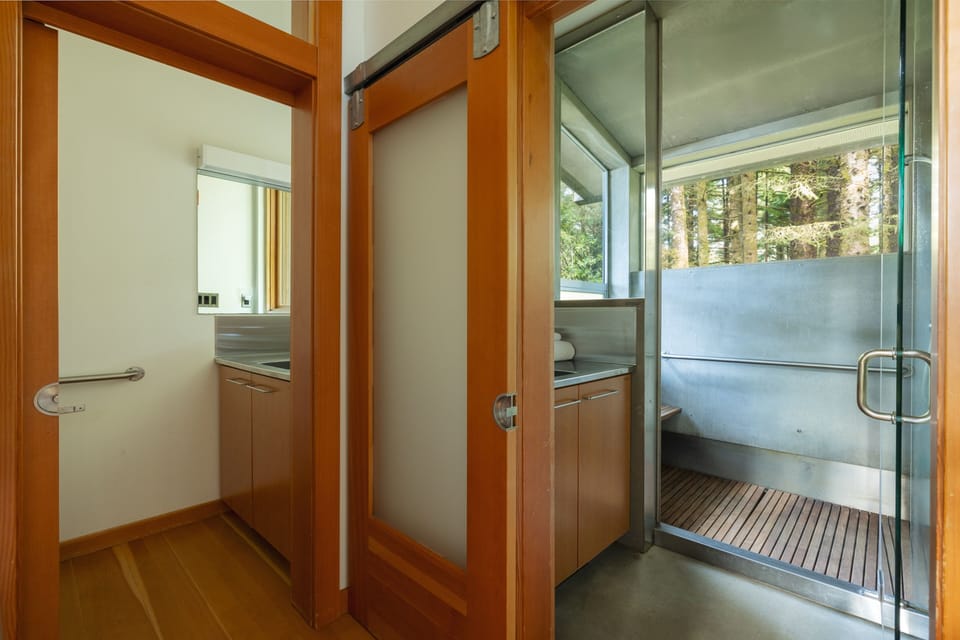 Step into your private sauna with sleek glass doors and natural wood accents, where relaxation awaits after your adventures.