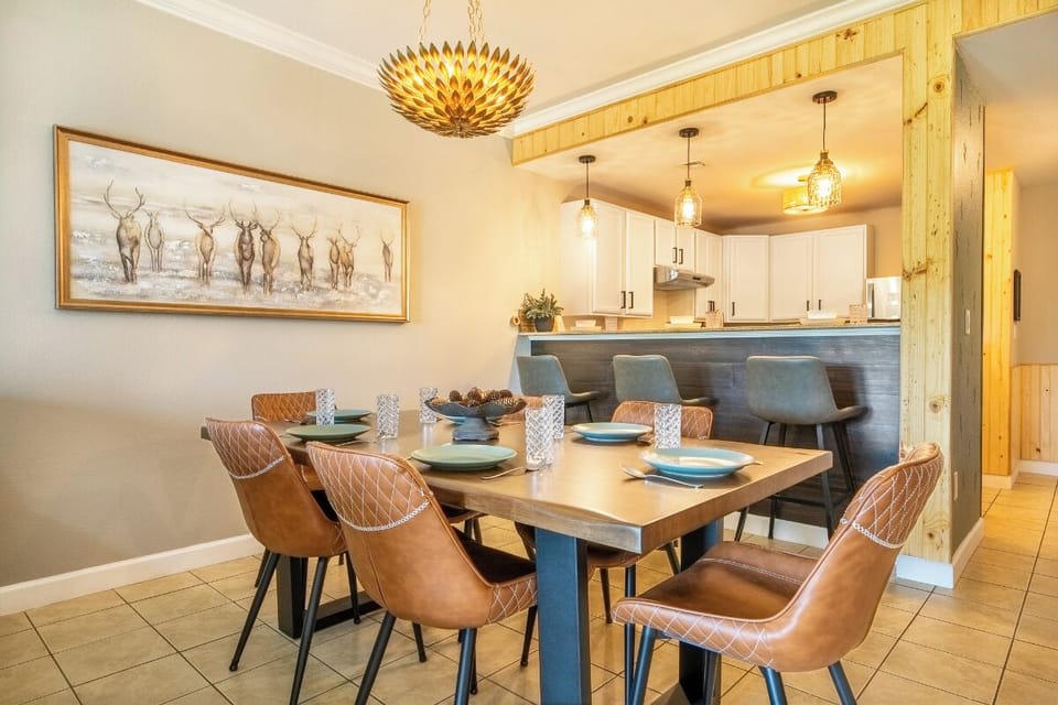 Gather around your elegant dining table where warm leather chairs and rustic wood beams create the perfect atmosphere for memorable meals together.