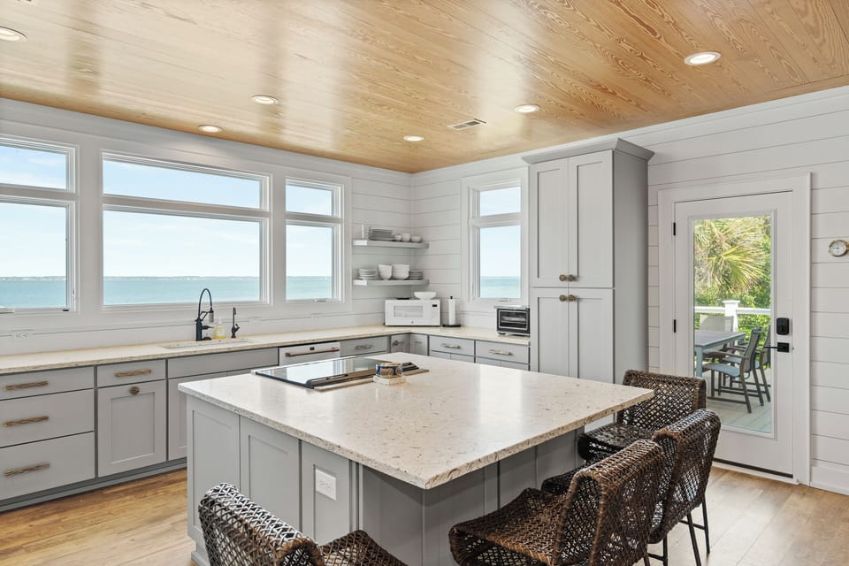 Cook while gazing at ocean views from this stunning kitchen with wood ceiling and coastal elegance.