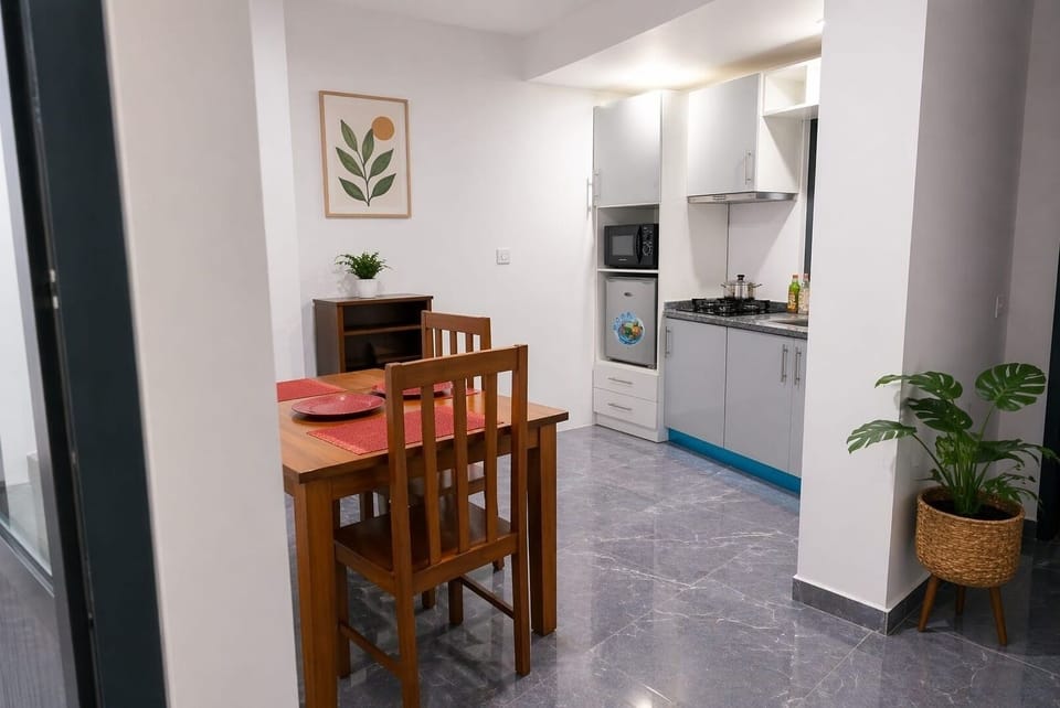 Espaço aberto com zona de refeições e cozinha integrada, moderno e funcional.