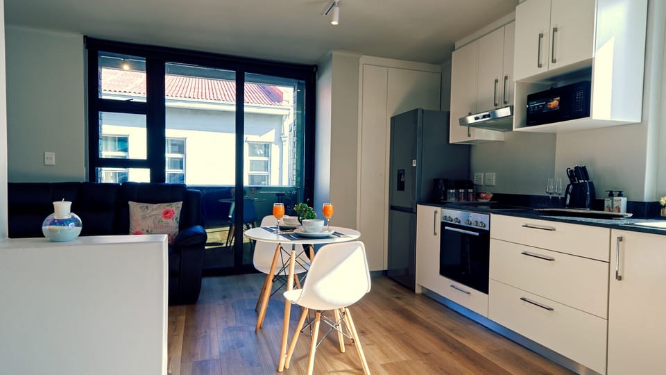 Fully equipped kitchen with dining space, full-size fridge and balcony access