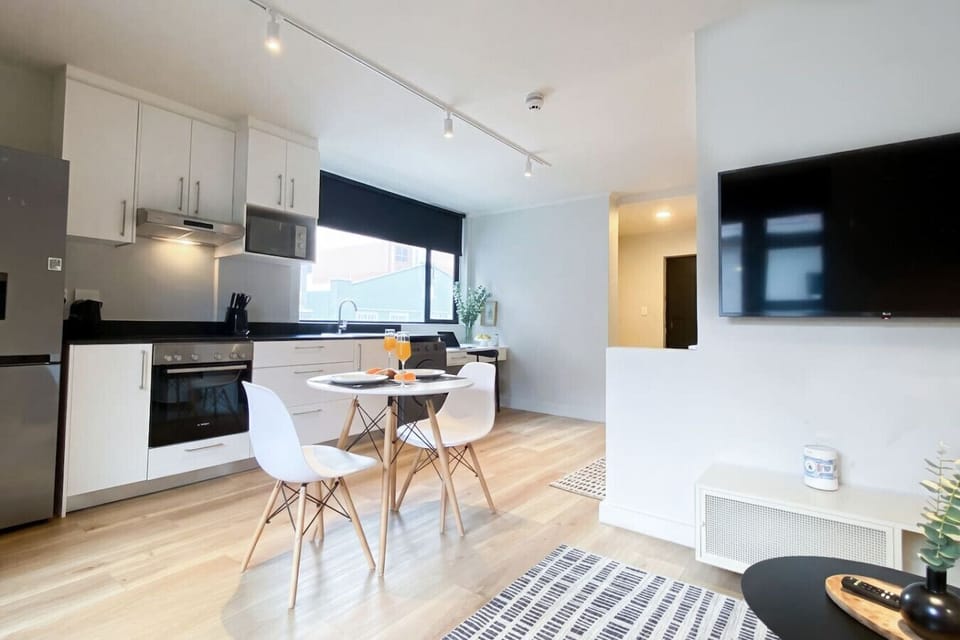 Open-plan kitchen and living space with dining area, smart TV, and modern finishes—perfect for a comfortable stay.