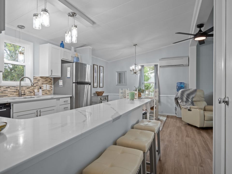 Gather around your stunning kitchen island with gleaming quartz countertops while natural light streams through windows, creating the perfect space for morning coffee.