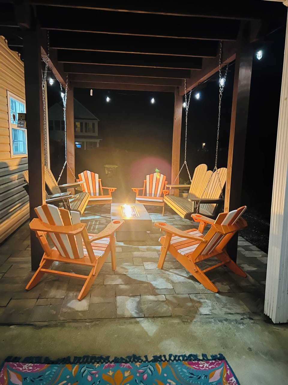 Gather around your private fire pit under twinkling lights, where cozy Adirondack chairs and gentle porch swings create the perfect evening retreat.
