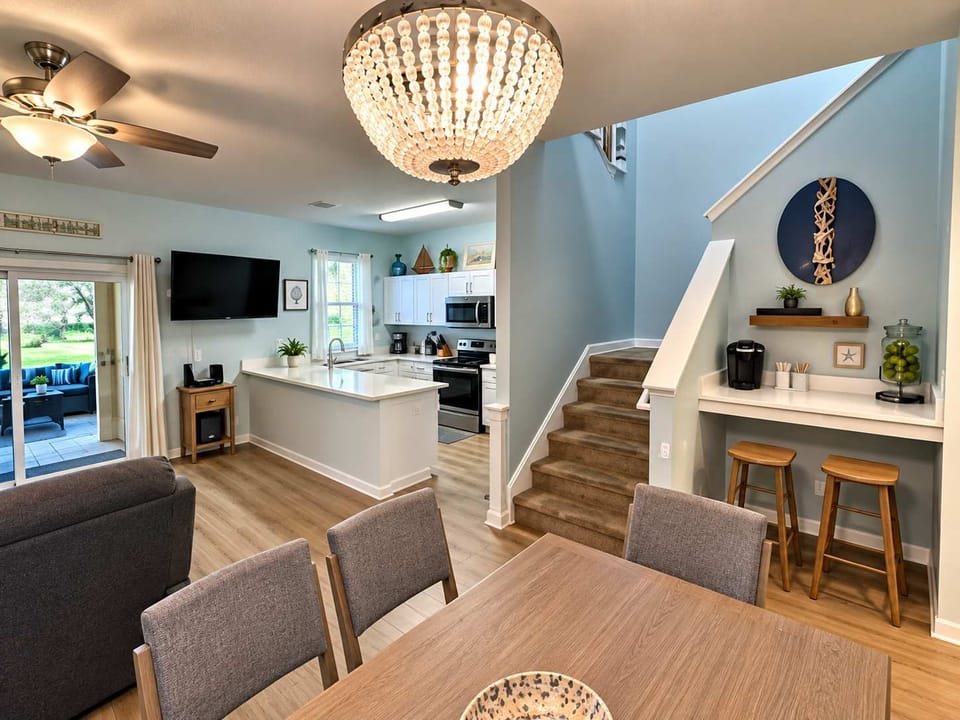 Gather together in this spacious, open-concept living and dining area. Featuring comfortable coastal-inspired seating, a dining table for group meals, and beautiful natural light.