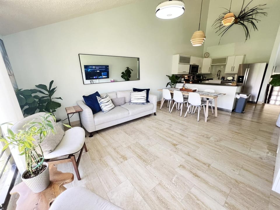 Bright, stylish living room with cozy sofa, dining area, relaxing vibe