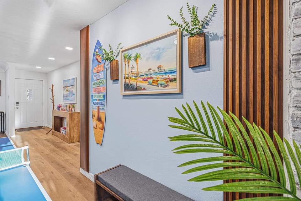 Bright hallway with coastal-inspired décor leading into the main living and game spaces 