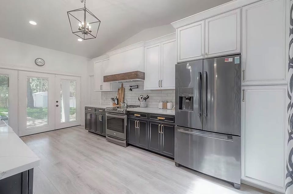 Bright chef’s kitchen with pro range, quartz tops, and French doors